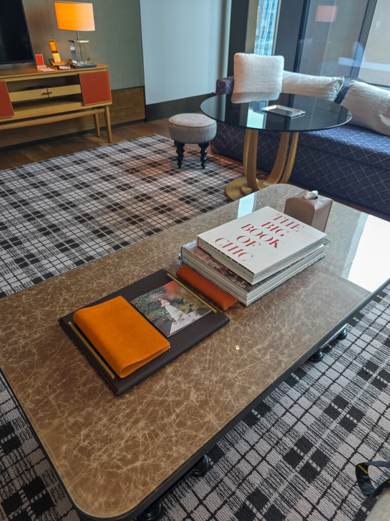 Rosewood Hong Kongの客室リビングルームにある机と本